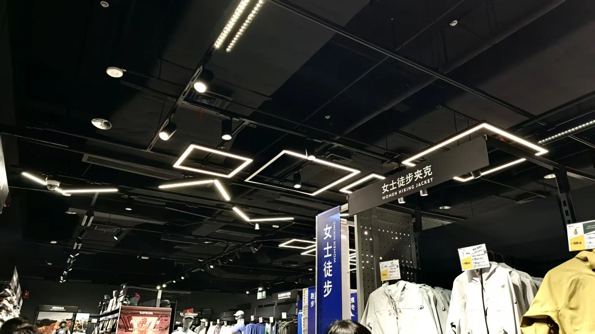 Square-shaped linear lights creating geometric lighting patterns in a Decathlon retail space
